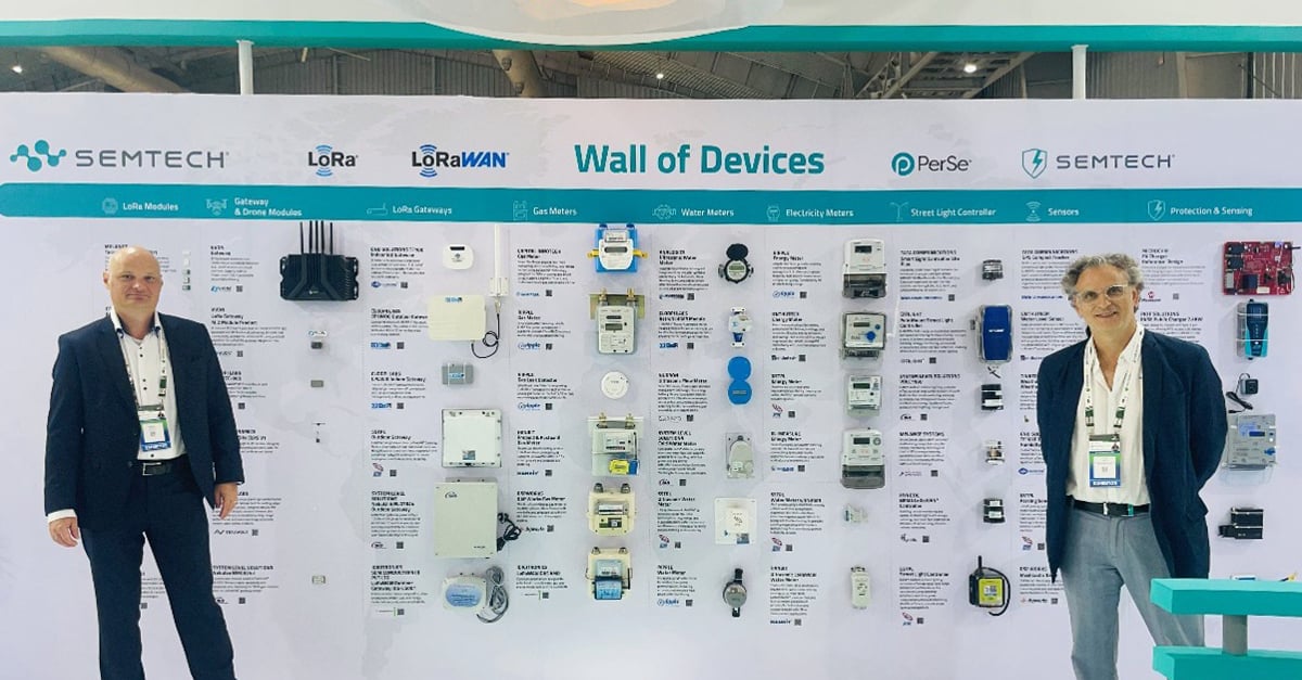 Mr. Robert Comanescu, vice president of applications engineering, R&D and Mr. Carlo Tinella, director of product marketing for LoRa at Semtech posing at the LoRa Wall of Devices at the Semtech Booth.