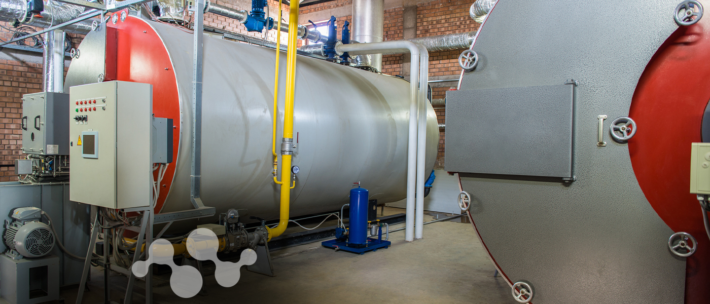 Industrial boiler room with large metal tanks and piping infrastructure showcasing industrial IoT sensor deployment environment