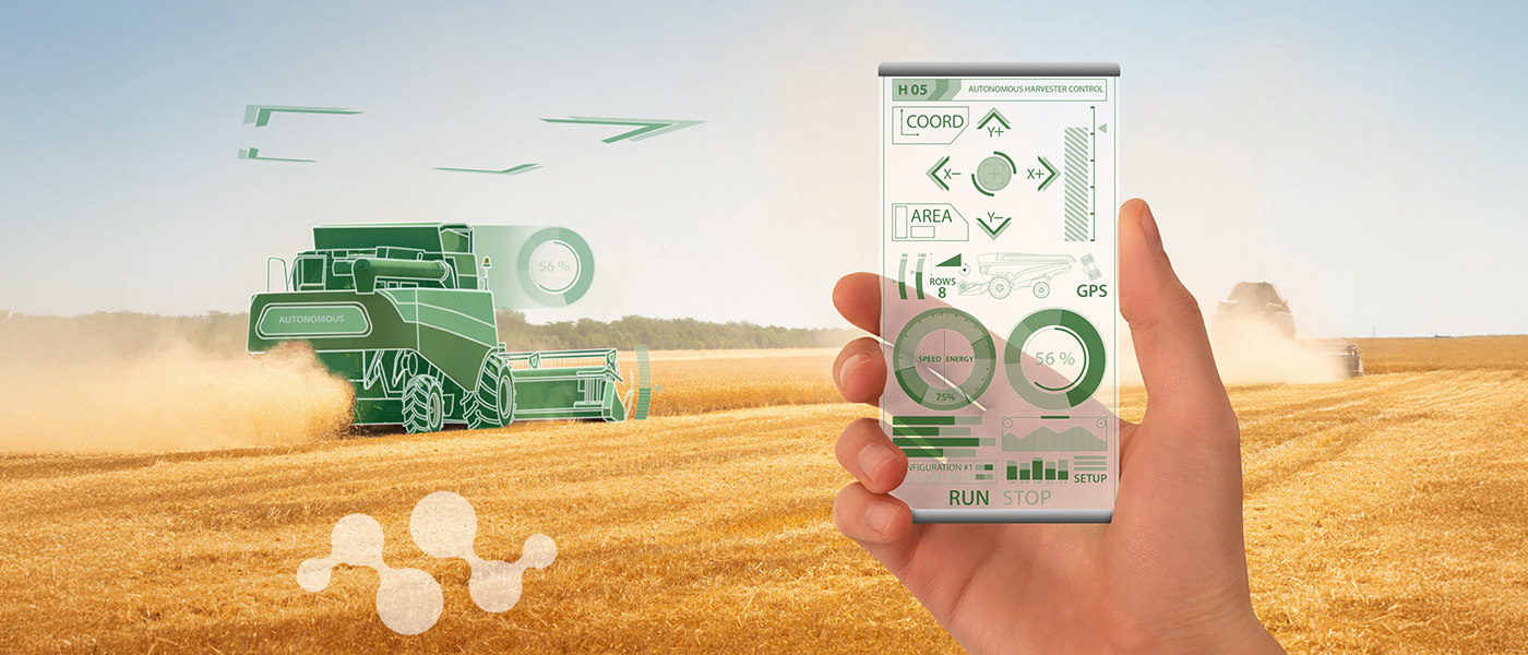 Hand holding transparent digital control interface displaying autonomous harvester control dashboard with GPS, speed, and energy metrics, while connected green combine harvester operates autonomously in golden wheat field. Semtech icon appears faintly on the left