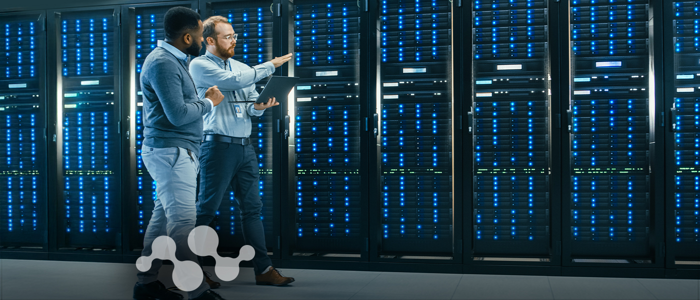 Two engineers collaborating in modern data center with server racks, representing Semtech's 2010s innovations in low-power networking, surge protection, and optical communication technologies